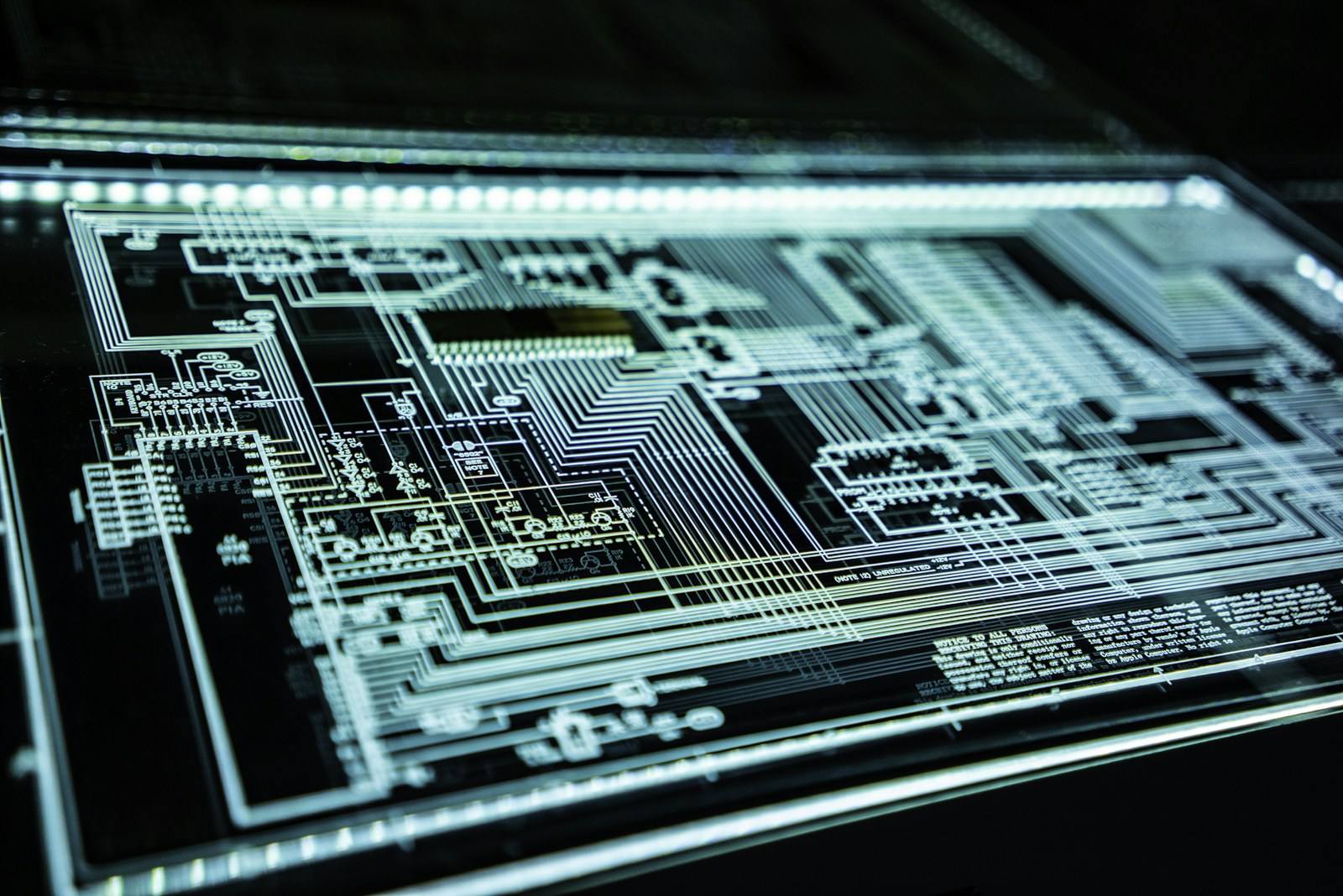 Illuminated circuit-board pathways on a dark background
